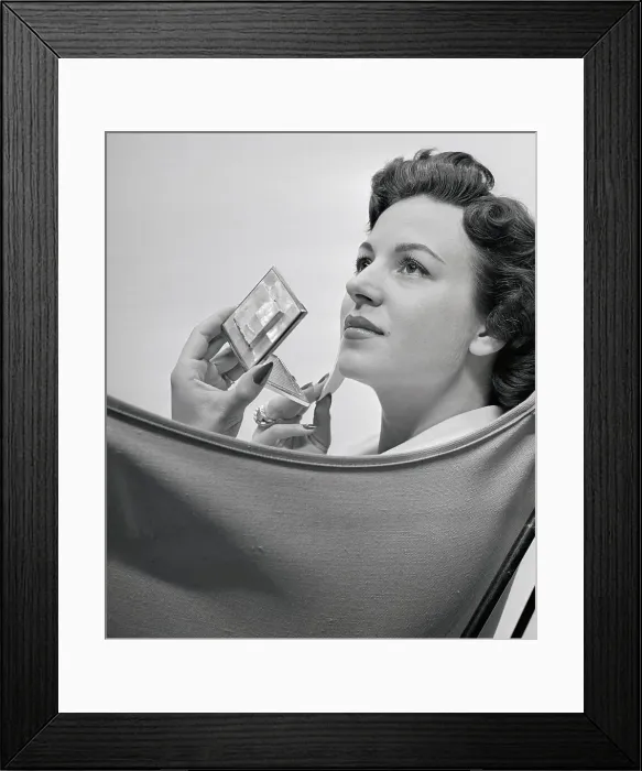 Framed Print : Woman Applying Makeup with a Compact Framed Print : Woman Applying Makeup with a Compact