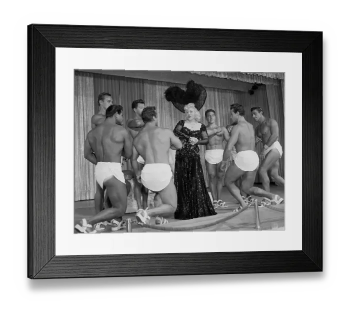 Framed Print : Mae West Posing in Center of Muscle Men