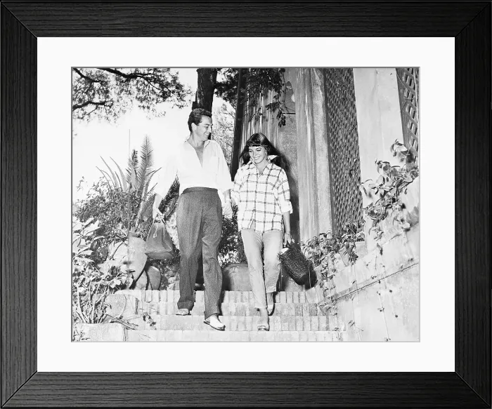 Framed Print : Sydney Chaplin and Joan Collins Walking