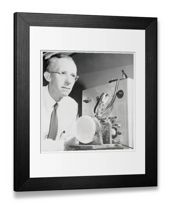 Framed Print : Dr. Edwin Muller Examining Microscope Display