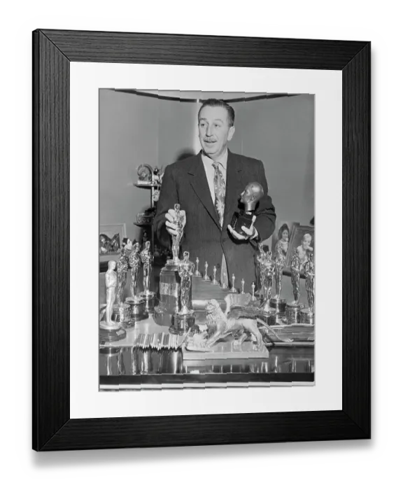 Framed Print : Walt Disney Standing over Table of Trophies
