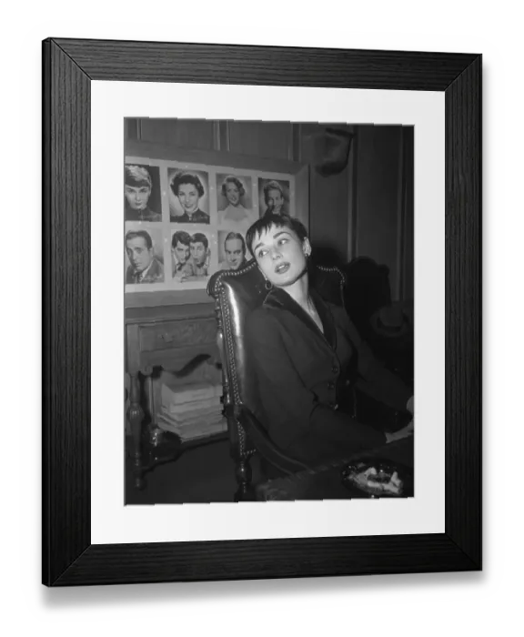 Framed Print : Audrey Hepburn Sitting with Wall of Portraits Behind Her Framed Print : Audrey Hepburn Sitting with Wall of Portraits Behind Her