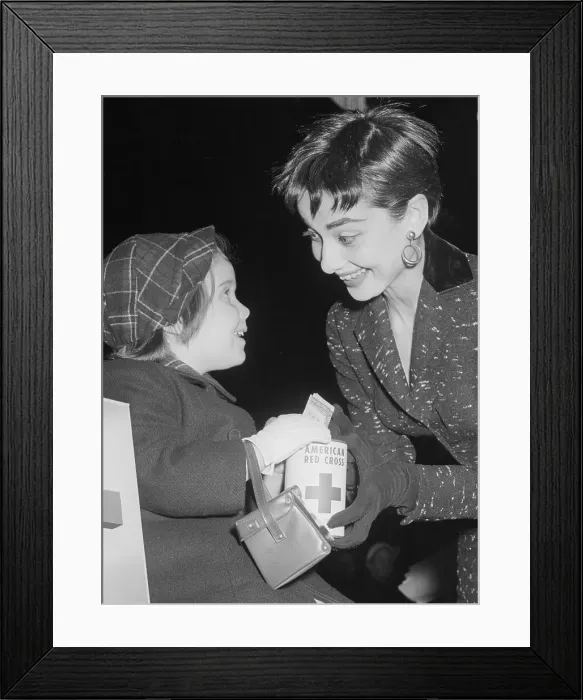 Framed Print : Audrey Hepburn with Girl Donating to Red Cross Framed Print : Audrey Hepburn with Girl Donating to Red Cross