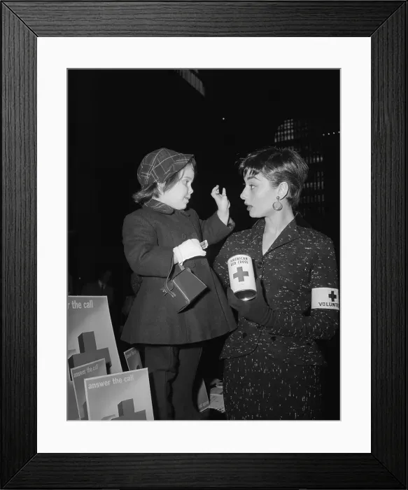 Framed Print : Audrey Hepburn Holding Red Cross Can and Talking With Young Girl Framed Print : Audrey Hepburn Holding Red Cross Can and Talking With Young Girl