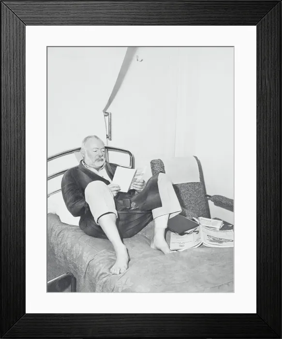 Framed Print : Ernest Hemingway Reading in Bed Framed Print : Ernest Hemingway Reading in Bed