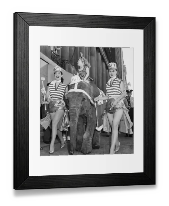 Framed Print : Two Scantily-Clad Women Lead Elephant Framed Print : Two Scantily-Clad Women Lead Elephant