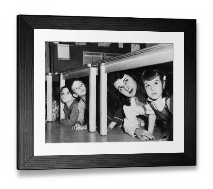 Framed Print : Teacher And Children Crouching Under Table