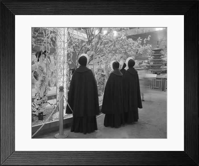 Framed Print : Contrast. Four Catholic nuns, dressed in their somber black habits, study the gay Framed Print : Contrast. Four Catholic nuns, dressed in their somber black habits, study the gay