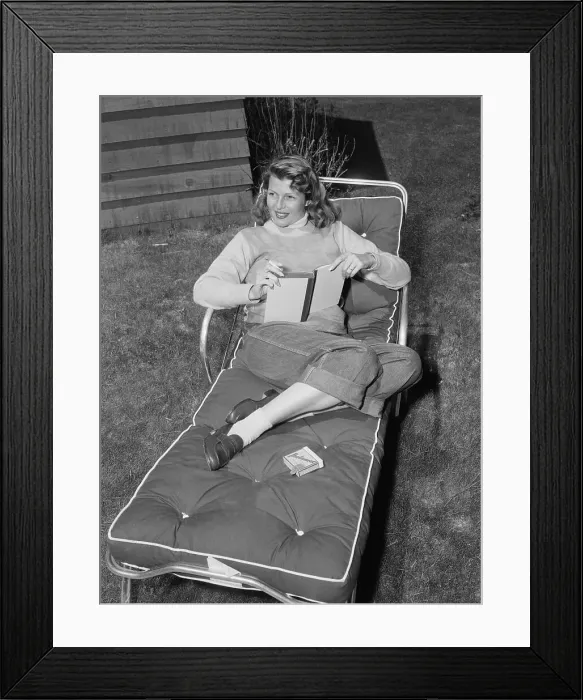 Framed Print : Rita Hayworth Relaxing on Lounge Chair with Book Framed Print : Rita Hayworth Relaxing on Lounge Chair with Book
