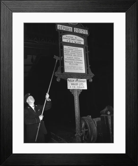 Framed Print : Man Changing Train Station Sign with Pole Framed Print : Man Changing Train Station Sign with Pole