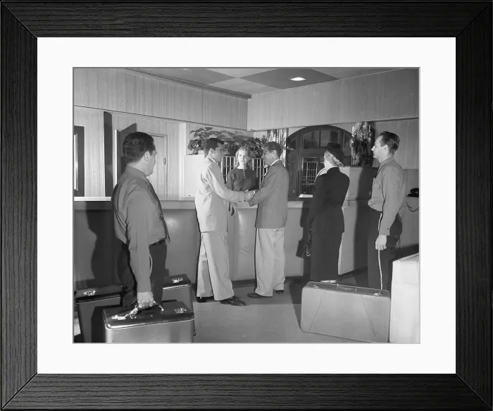 Framed Print : Hotel Manager Greeting Guests at Desk Framed Print : Hotel Manager Greeting Guests at Desk