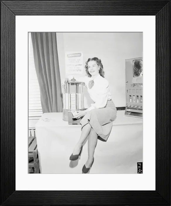 Framed Print : Young Woman Sitting on Table Beside Cigarette Machine Framed Print : Young Woman Sitting on Table Beside Cigarette Machine