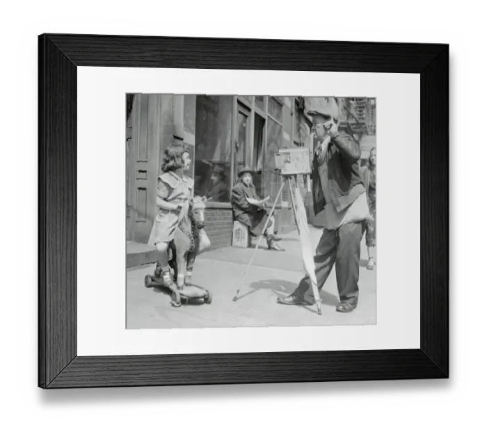 Framed Print : Photographer is taking picture of girl (6-7) sitting on toy horse Framed Print : Photographer is taking picture of girl (6-7) sitting on toy horse