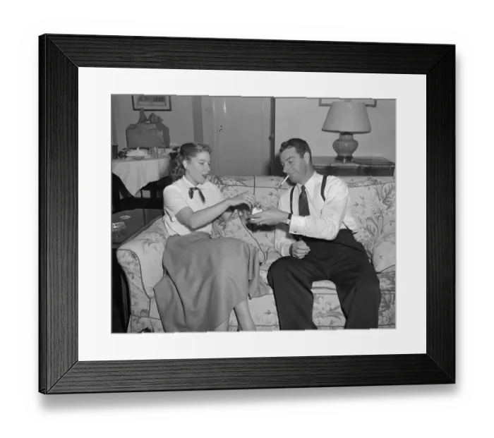Framed Print : Joe DiMaggio Smoking with a Woman on Couch Framed Print : Joe DiMaggio Smoking with a Woman on Couch