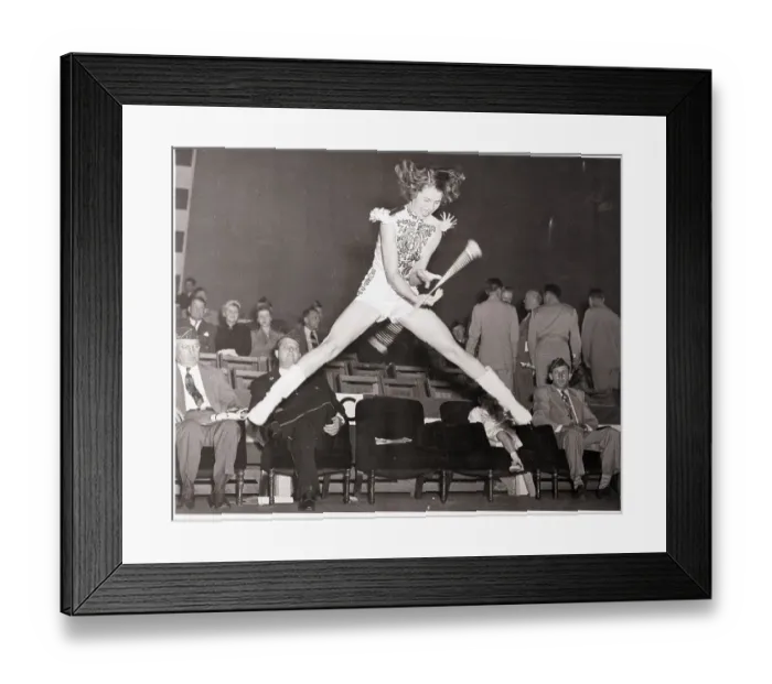 Framed Print : Majorette Jumping While Twirling Baton