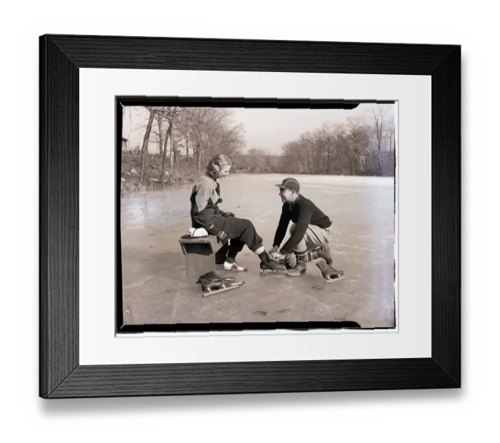 Framed Print : Man Lacing a Woman's Ice Skate Framed Print : Man Lacing a Woman's Ice Skate