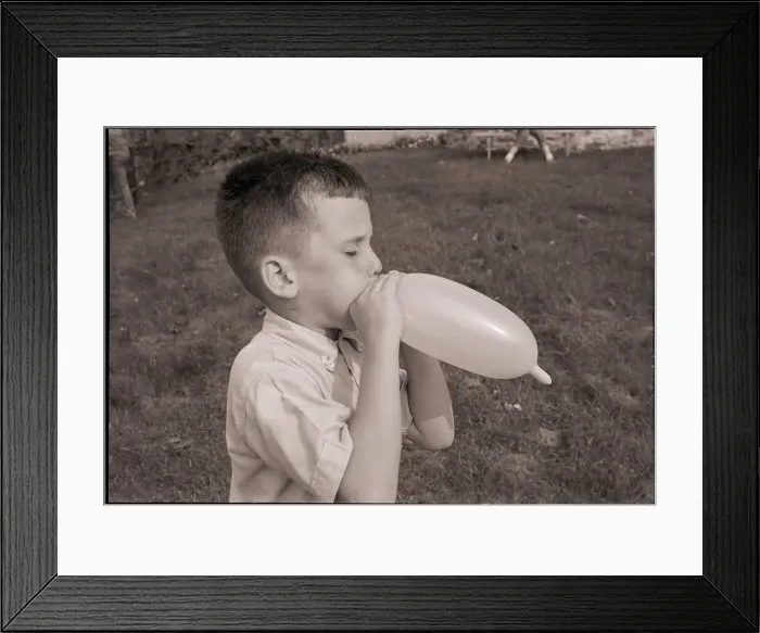 Framed Print : Boy Blowing a Balloon Framed Print : Boy Blowing a Balloon