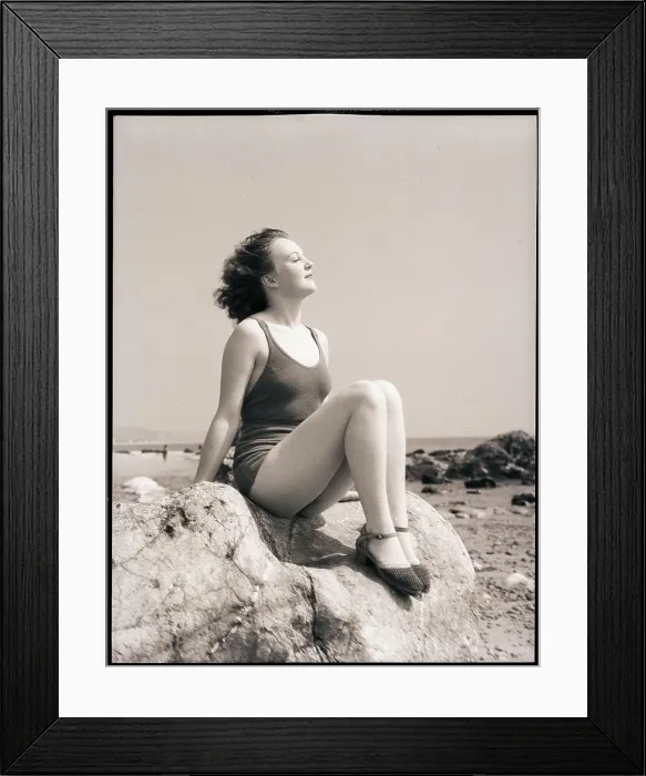 Framed Print : Young Woman Sitting on Beach Rocks Framed Print : Young Woman Sitting on Beach Rocks