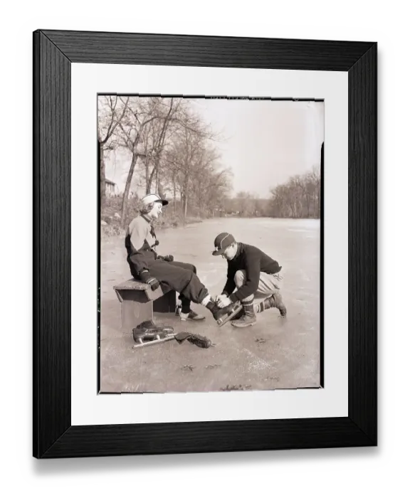 Framed Print : Man Putting on Woman's Ice Skates Framed Print : Man Putting on Woman's Ice Skates
