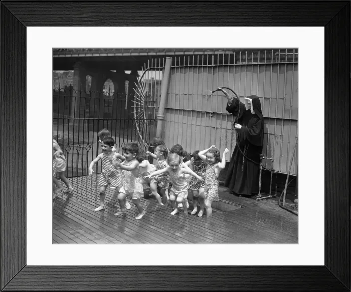 Framed Print : Nun splashing water on children Framed Print : Nun splashing water on children
