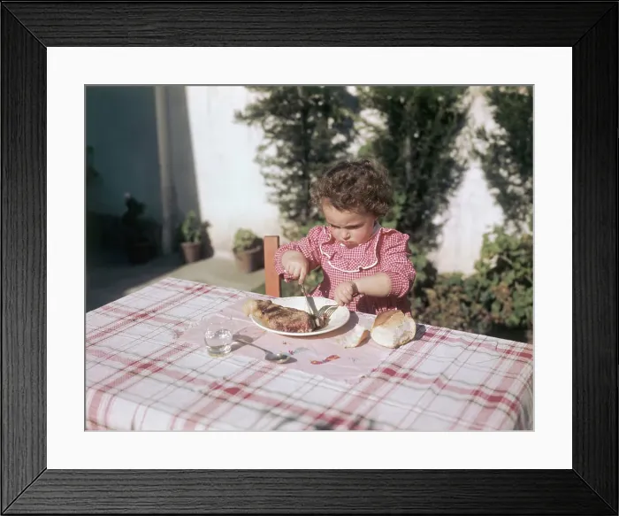 Framed Print : Little Girl Eating Big Steak Framed Print : Little Girl Eating Big Steak