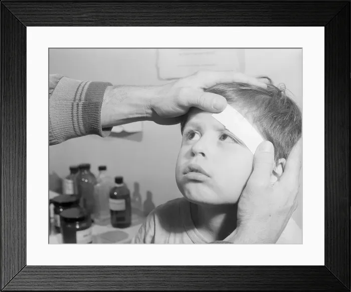 Framed Print : Child Getting Forehead Bandaged Framed Print : Child Getting Forehead Bandaged