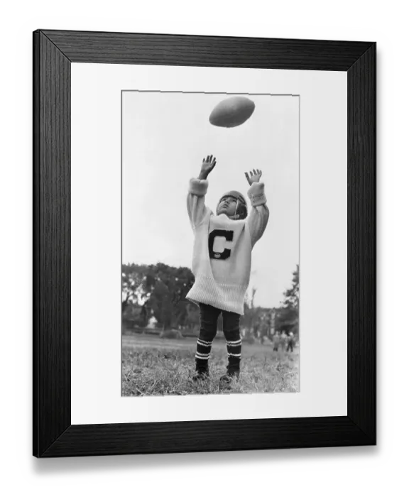 Framed Print : Boy (6-7) playing with rugby ball Framed Print : Boy (6-7) playing with rugby ball