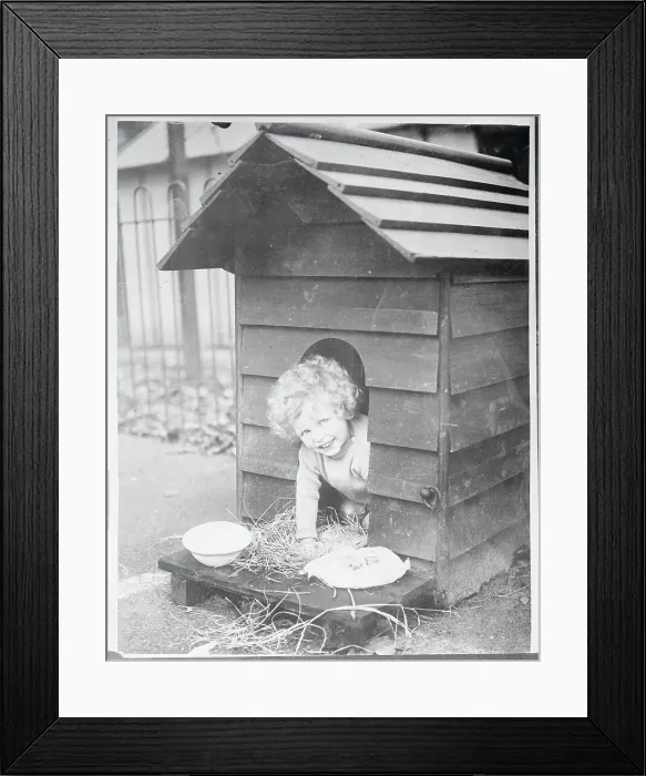 Framed Print : Child Sitting in a Doghouse Framed Print : Child Sitting in a Doghouse