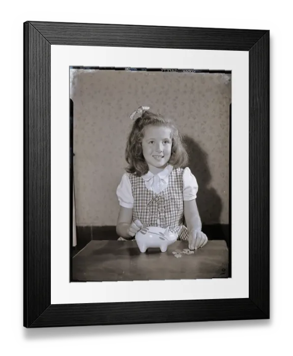 Framed Print : Girl Putting Money In Piggy Bank