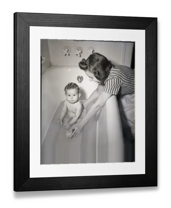 Framed Print : Woman Bathing Infant in Tub Framed Print : Woman Bathing Infant in Tub