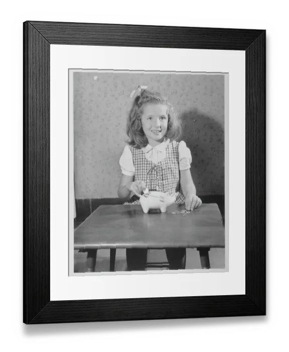 Framed Print : Girl Putting Money In Piggy Bank