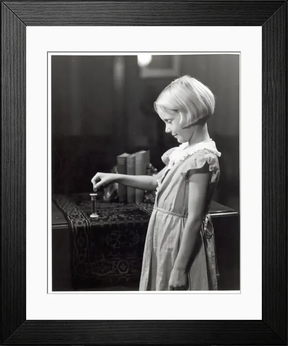 Framed Print : Girl Putting Money Into Dime Bank Framed Print : Girl Putting Money Into Dime Bank