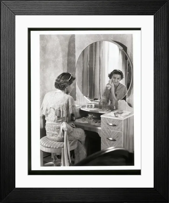 Framed Print : Young Woman Applying Face Cream at Vanity Framed Print : Young Woman Applying Face Cream at Vanity