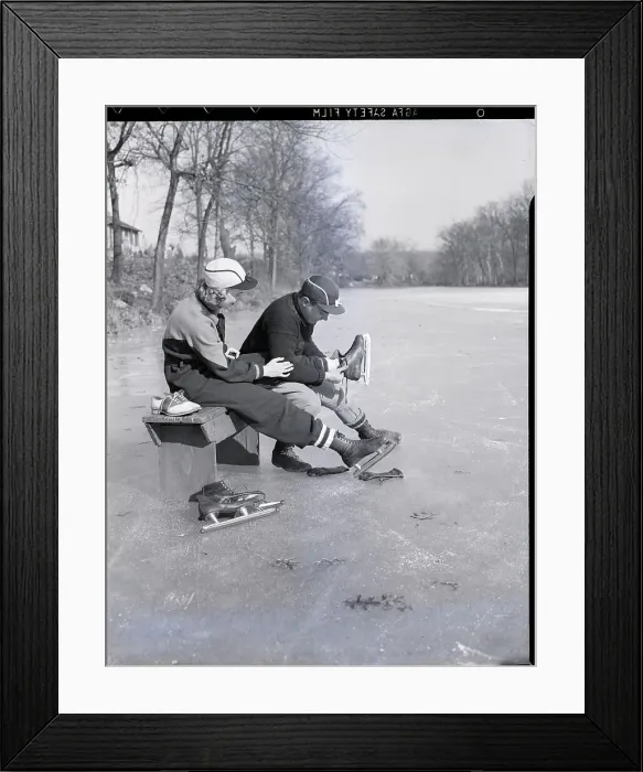 Framed Print : Man Puts Ice Skates On Woman At Rink Framed Print : Man Puts Ice Skates On Woman At Rink