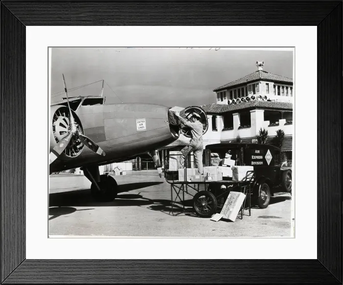 Framed Print : Postal Worker Loads Packages Into Plane Framed Print : Postal Worker Loads Packages Into Plane