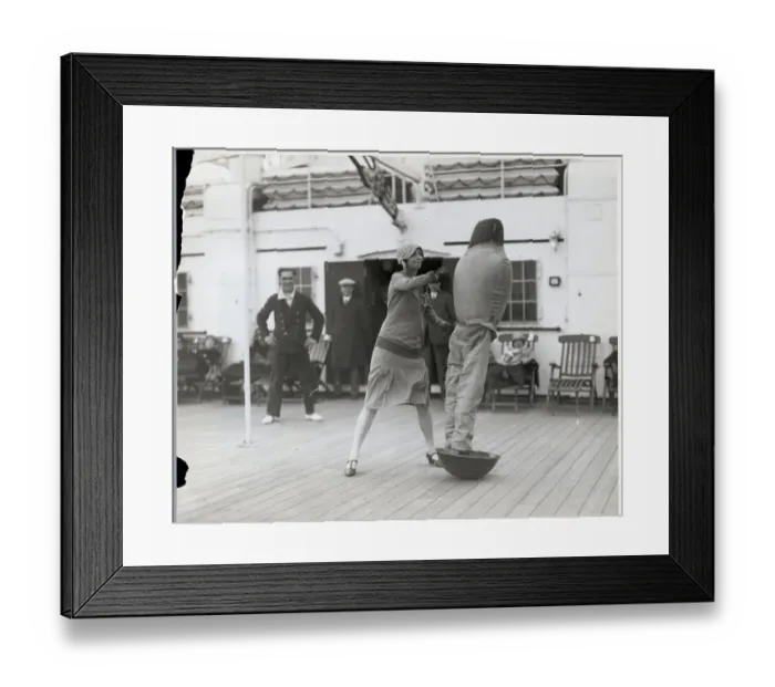 Framed Print : Woman Hits Dummy Figure on Ship Deck Framed Print : Woman Hits Dummy Figure on Ship Deck