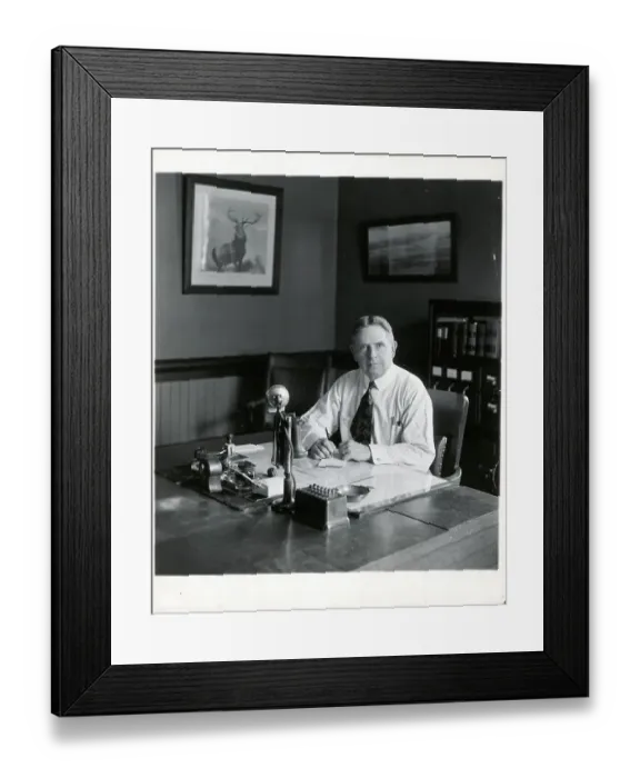 Framed Print : Office Manager At Desk Looking At Camera Framed Print : Office Manager At Desk Looking At Camera