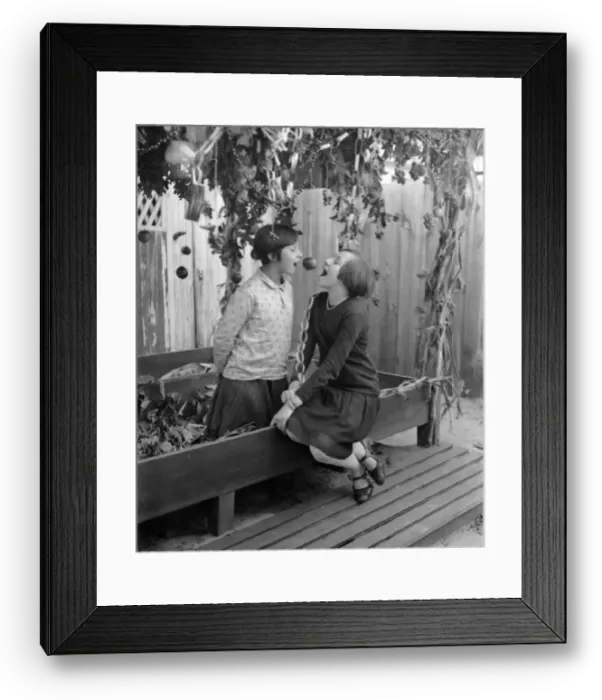 Framed Print : Two girls (10-12) eating apple Framed Print : Two girls (10-12) eating apple