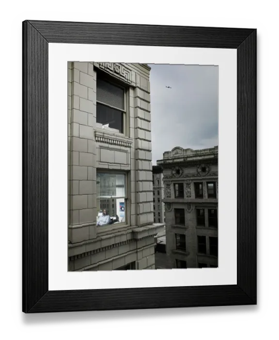 Framed Print : Businessman looking out of corner office