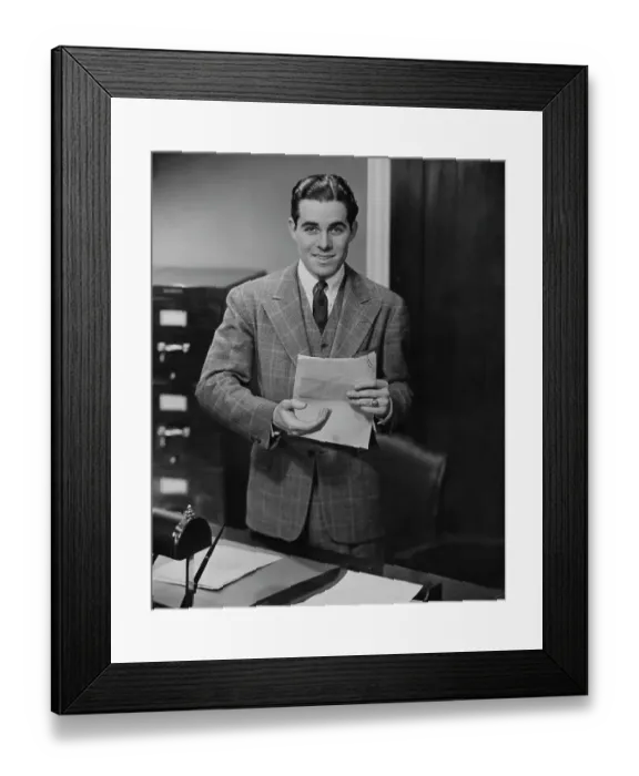 Framed Print : Paperwork. A young office worker with a document, circa 1955