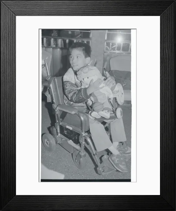 Framed Print : Handicapped Boy Holding New Disabled Doll Framed Print : Handicapped Boy Holding New Disabled Doll