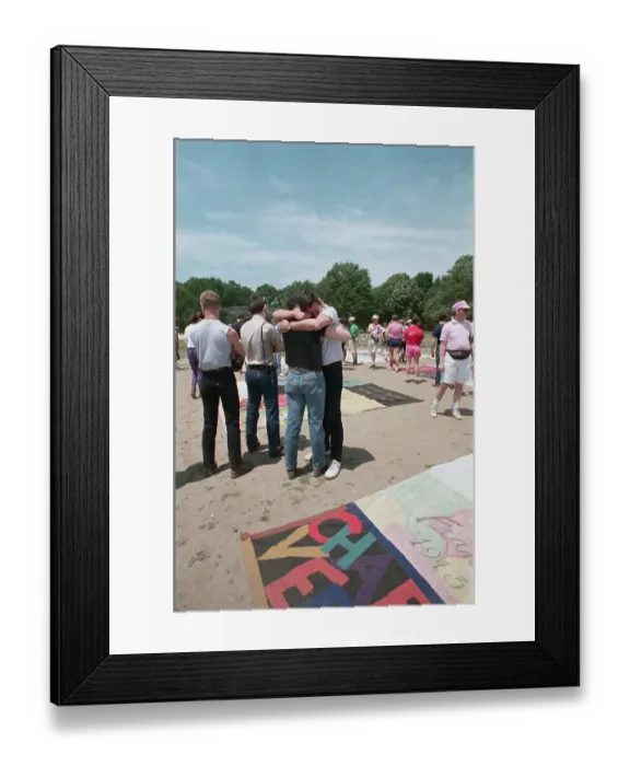 Framed Print : Two Men Embracing Near Memorial Quilt