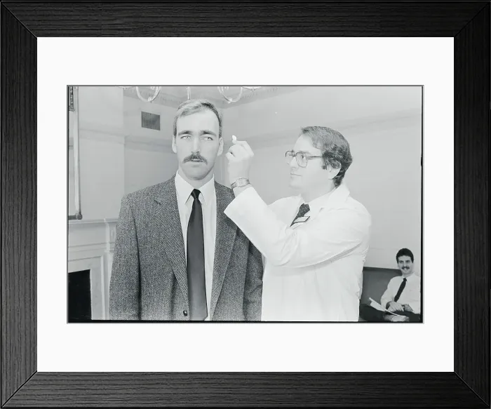 Framed Print : Doctor Holding Polymer Wafer to Head of Patient