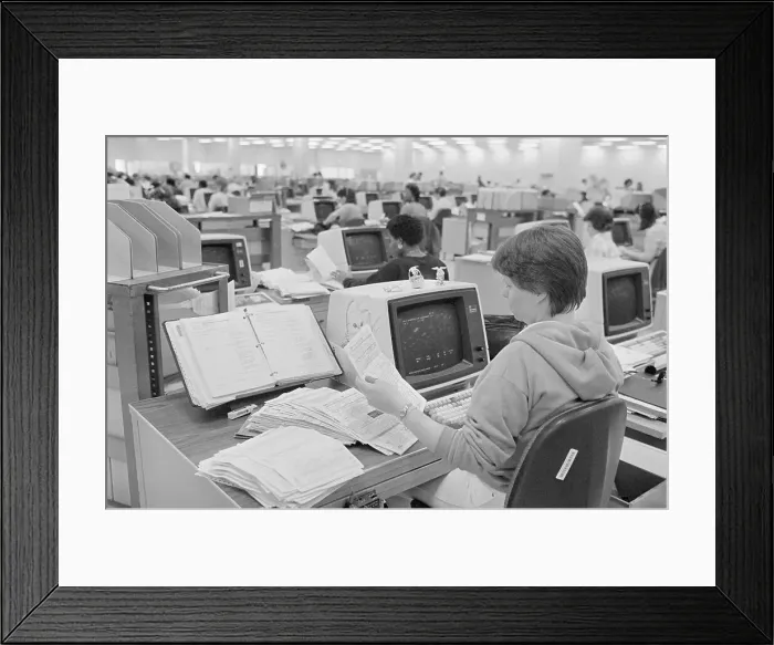 Framed Print : IRS Worker Checks Through Pile Of Forms