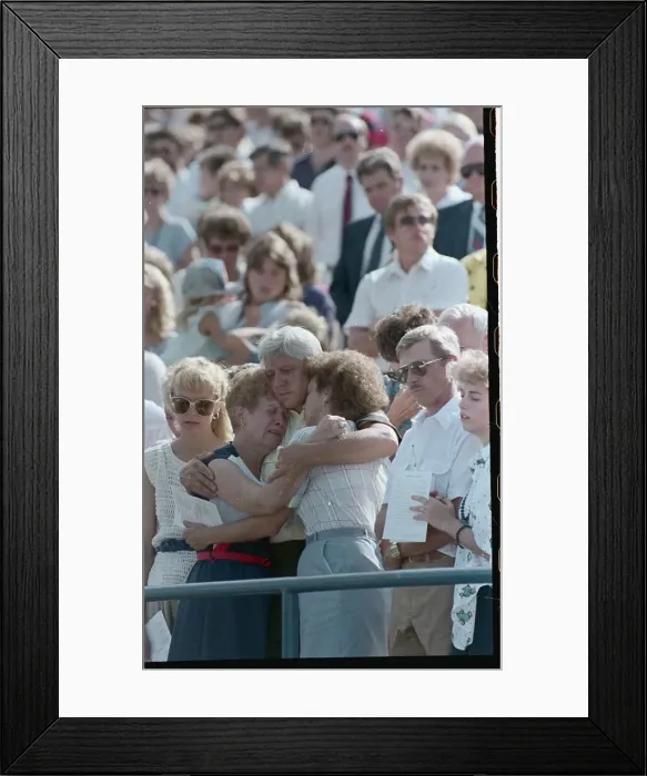 Framed Print : Mournful Family Members Embracing at Memorial Framed Print : Mournful Family Members Embracing at Memorial
