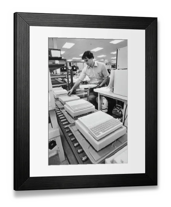 Framed Print : Worker Examines Apple IIc Computer Framed Print : Worker Examines Apple IIc Computer
