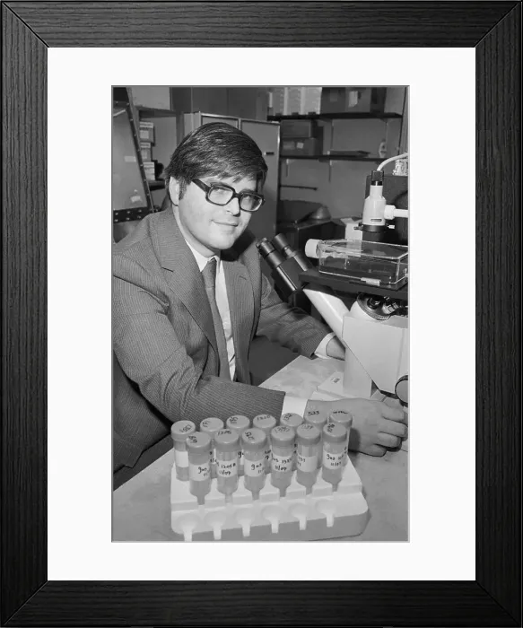 Framed Print : Doctor Smiling at Desk with Blood Samples Framed Print : Doctor Smiling at Desk with Blood Samples