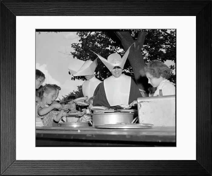 Framed Print : Two Nuns Serve Food to Children Framed Print : Two Nuns Serve Food to Children
