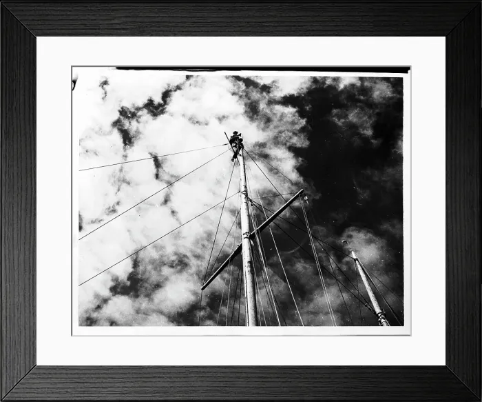 Framed Print : Man at Top of Ship's Mast Repairing a Light Framed Print : Man at Top of Ship's Mast Repairing a Light