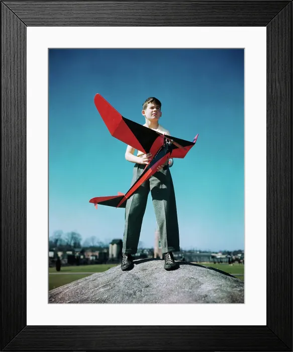Framed Print : Boy Standing on Mound with Red Plane in His Hands Framed Print : Boy Standing on Mound with Red Plane in His Hands